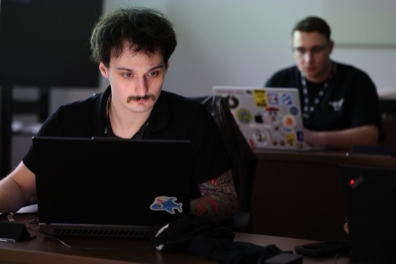 A hacker with a mustache staring into his laptop
