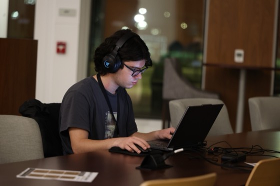 A hacker in glowing headphones coding late at night